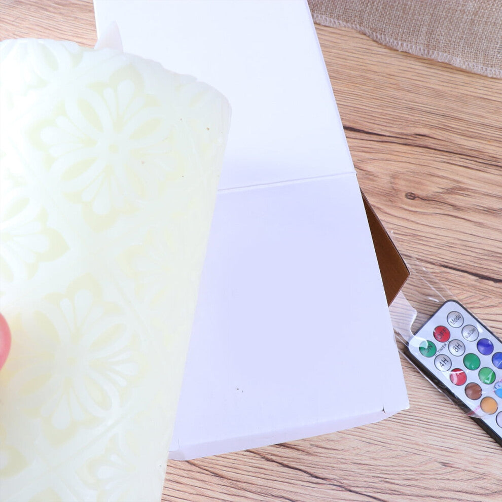 A 15cm white paraffin wax flameless LED candle featuring an intricate hollow flower pattern glowing softly on a decorative table.