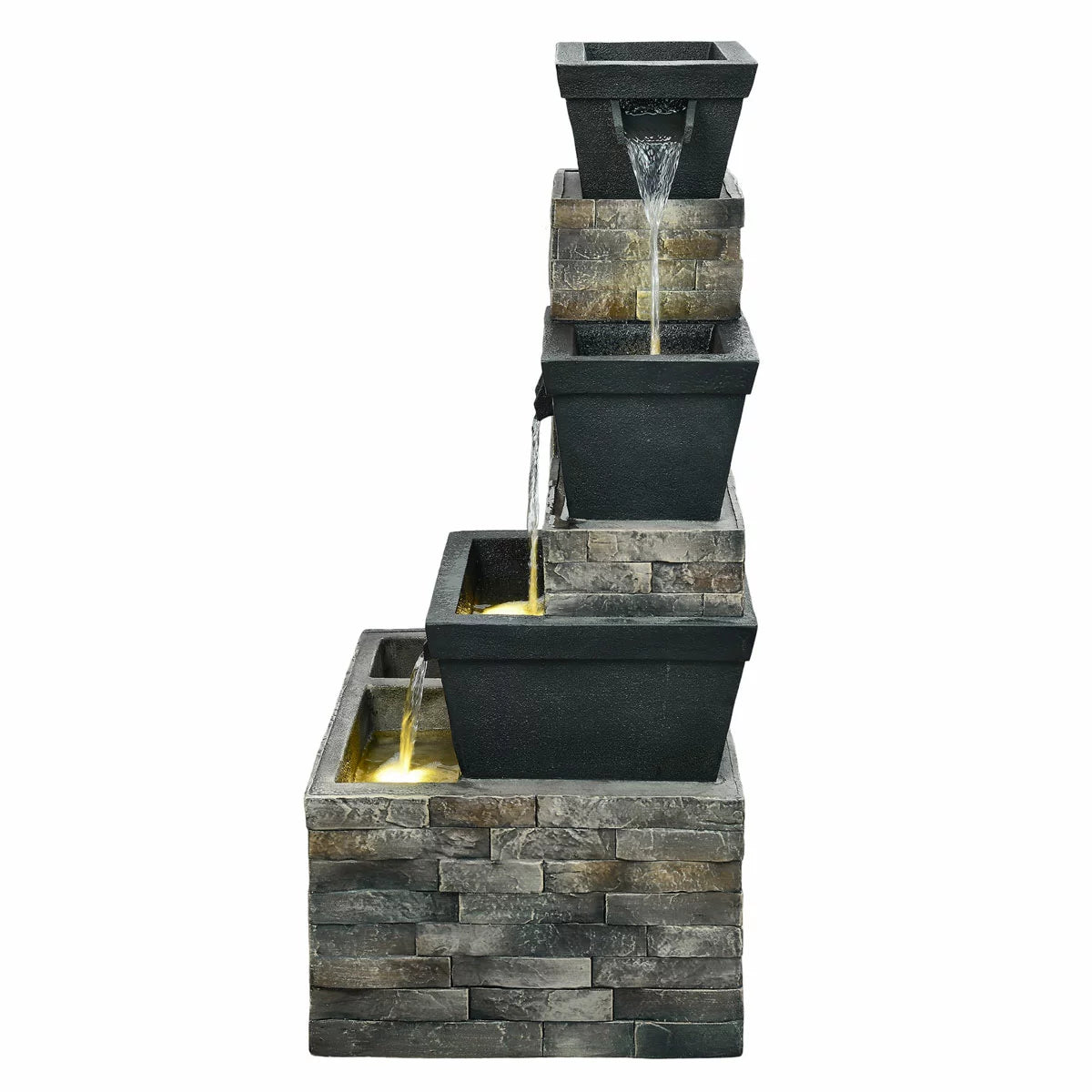 A 34.5-inch tiered brick-effect fountain glowing with warm LED lights on a stone patio, surrounded by green foliage at dusk