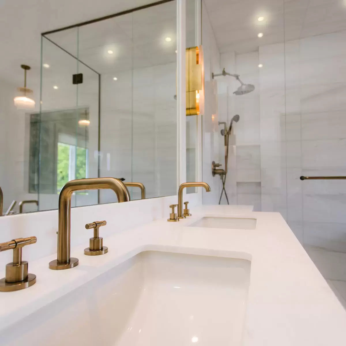 Two polished chrome 4lite WiZ smart downlights recessed into a clean white ceiling, casting a warm amber glow in a modern minimalist bathroom.