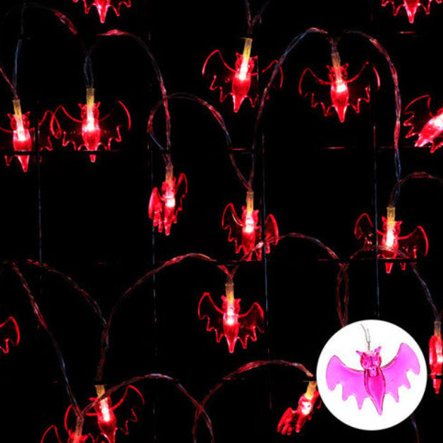 A 9.84ft string of 20 warm white LED Halloween lights glowing against a decorated indoor window display.