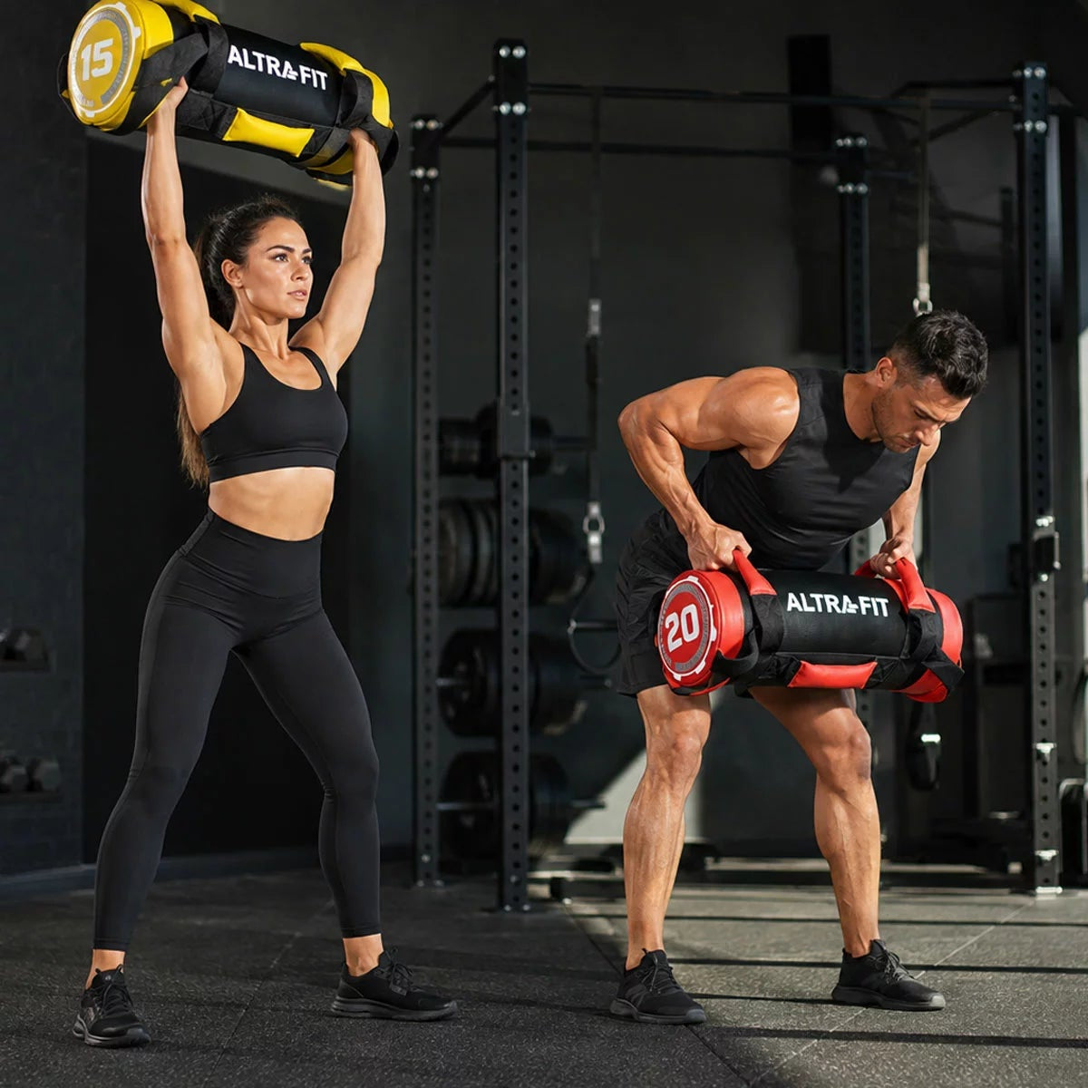 Black Altrafit heavy duty power bag with multiple red nylon grip handles placed on a dark gym floor.