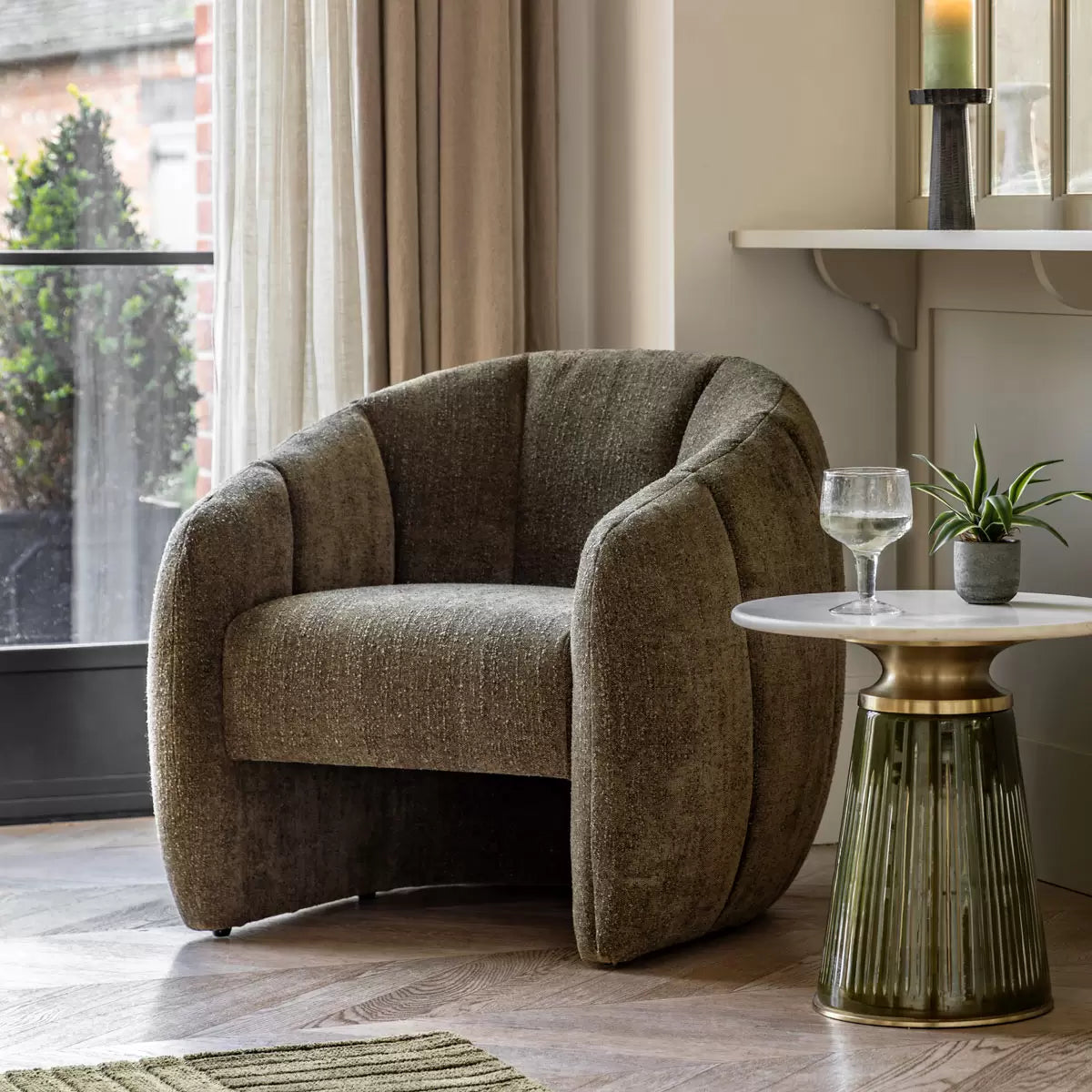 Front view of the Gallery Atella moss green bouclé tub chair, showcasing its vertical stitching details, rounded frame, and highly textured fabric.