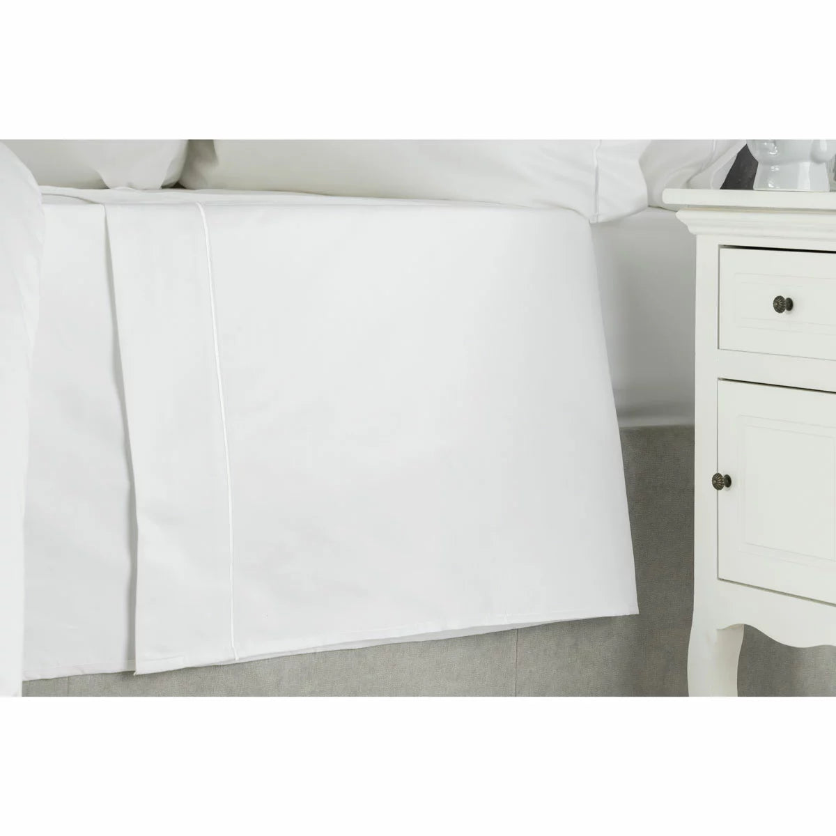 Neat fold of the Belledorm 1000 thread count white Egyptian cotton flat sheet showing the smooth sateen sheen on a modern bed setup.