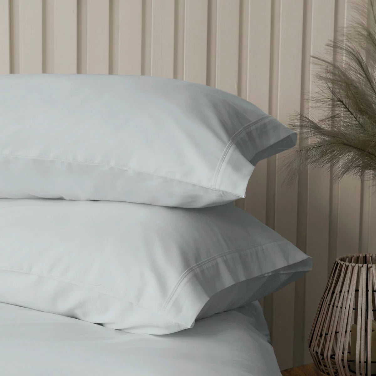 A studio shot of the platinum grey Belledorm bamboo cotton duvet cover set smoothly laid out on a bed, showcasing the silky finish of the fabric and the matching pillowcases.