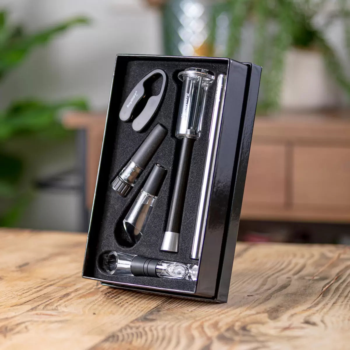 Matte black and stainless steel BergHOFF 5-piece wine tool set neatly arranged inside its premium black presentation box on a wooden tabletop.