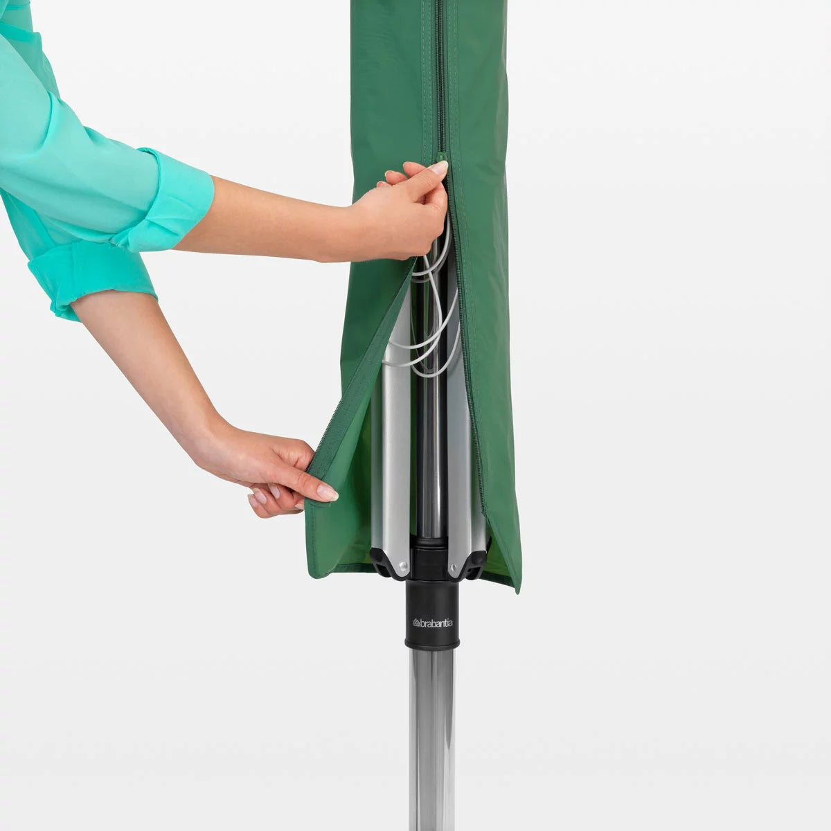 A Brabantia Lift-O-Matic 50m rotary airer standing in a well-maintained garden, featuring taut lines and a protective cover nearby on a clear, sunny day.