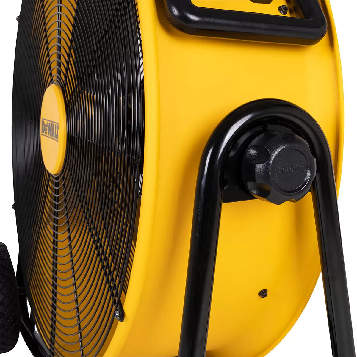 Yellow and black DEWALT 24 inch industrial floor fan DXF2410 with metallic blades and tubular steel frame resting on a concrete workshop floor.