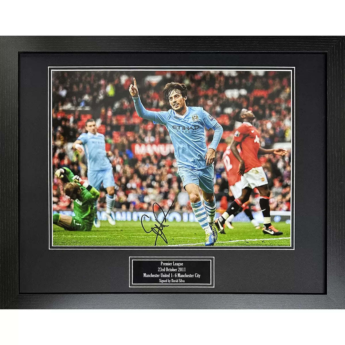 A framed, hand-signed action photograph of David Silva scoring during the 6-1 Manchester City derby victory, featuring a professional dark-finish frame.