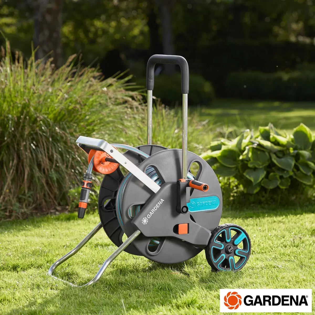 A blue and grey Gardena CleverRoll L Easy Hose Trolley with 50m of hose standing on a green lawn.