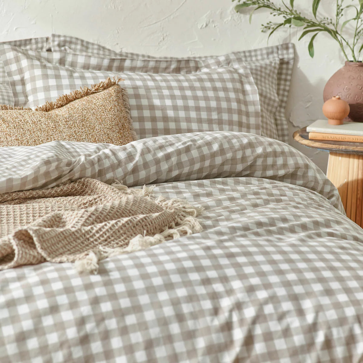 Flat-lay view of the single natural cotton gingham duvet cover set showcasing the reversible beige-and-white check pattern and structured Oxford border pillowcase on a rustic wood background.