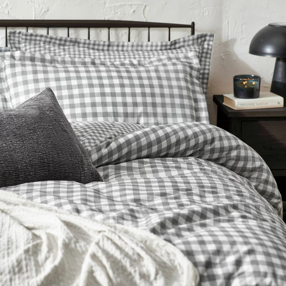 Overhead product shot of the grey and white gingham single duvet cover set neatly laid out on a gray bedframe with its matching Oxford border pillowcase highlighting the textured fabric finish.