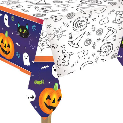 Flat layout of a colorful Halloween-themed plastic tablecover featuring friendly ghost and pumpkin illustrations spread over a dining table setup.