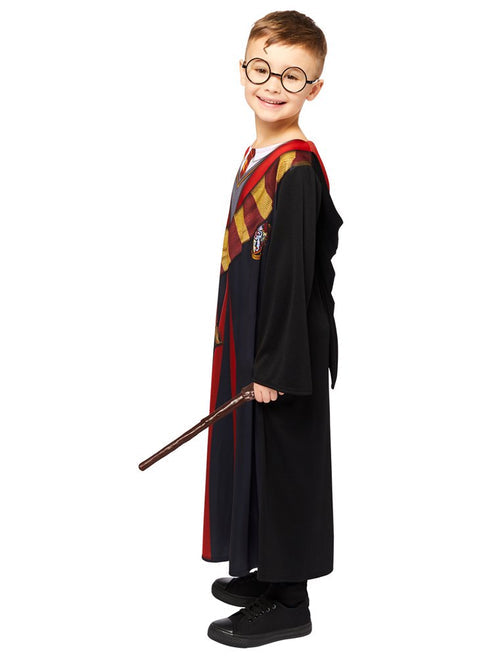 Front view of child wearing deluxe Harry Potter black robe with embroidered house crest and red satin hood lining in studio lighting.