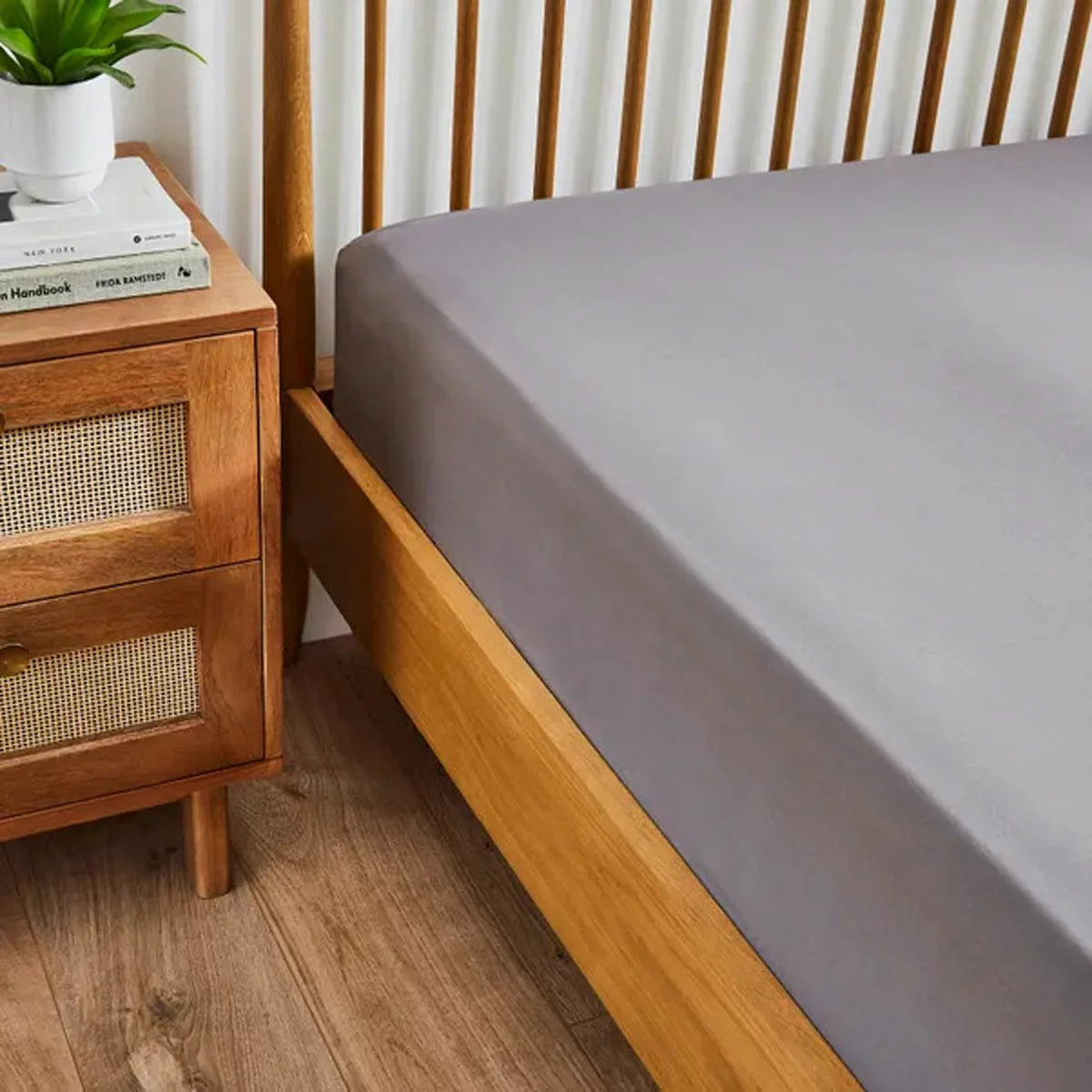 A pack of two neatly folded double-sized Hotel Signature cotton sateen fitted sheets showing the thick elastic corner grip on a clean bed.
