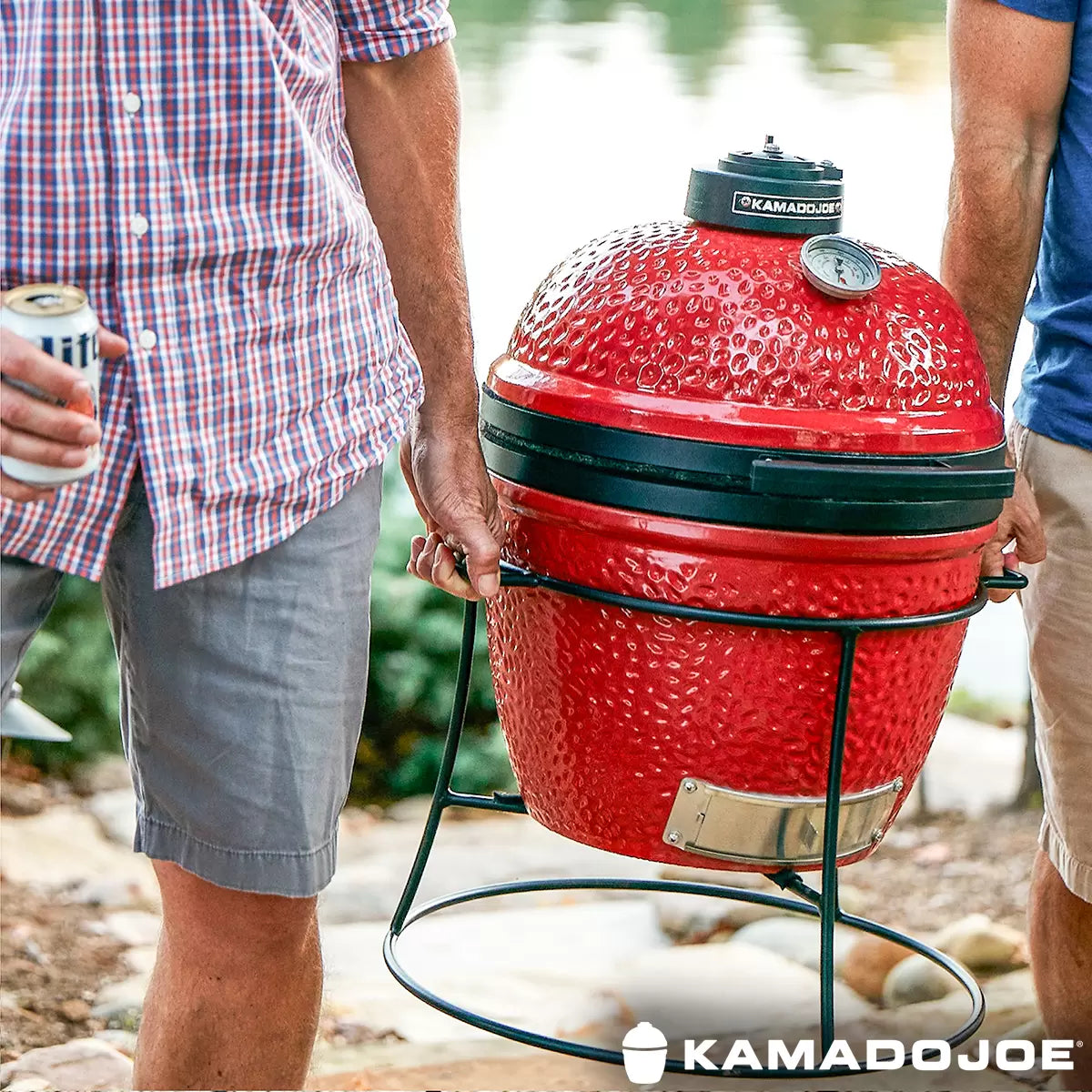 Kamado Joe Junior 13.5-inch Ceramic Charcoal Barbecue Grill set up for cooking on an outdoor patio with its protective cover displayed nearby.