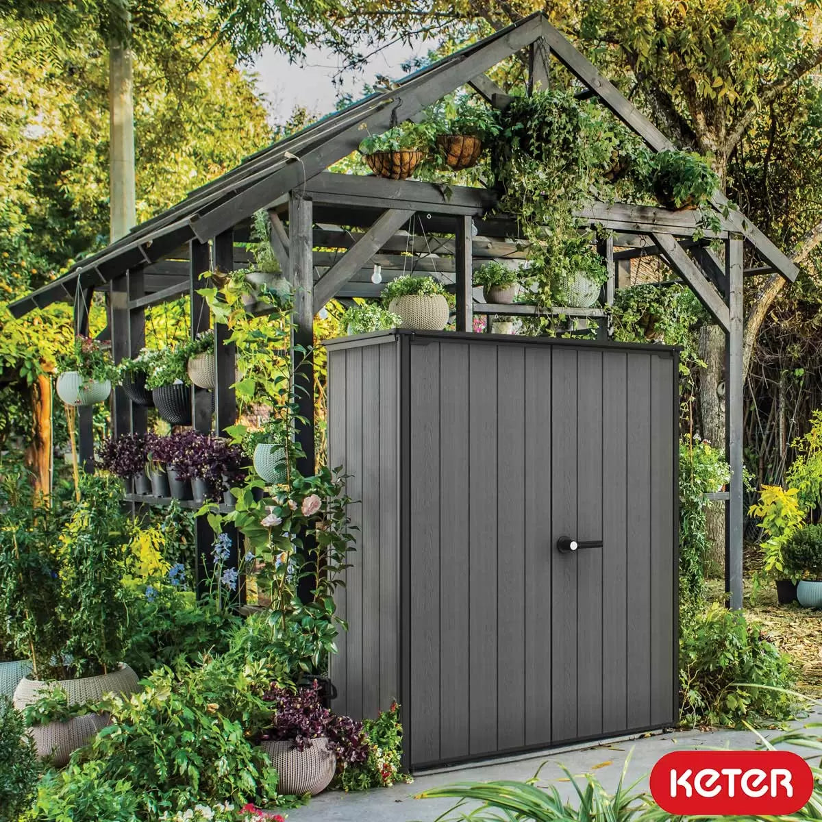 Keter Cortina Alto 1415L vertical storage shed with doors open, showcasing interior shelving organised with garden tools on a patio.