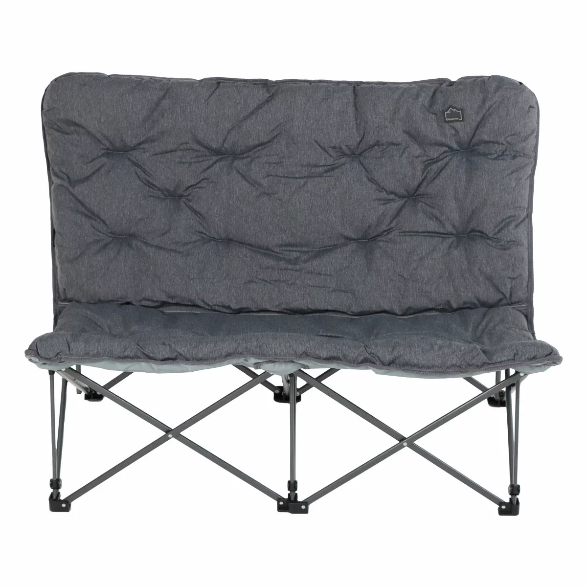 The KingCamp Oversized Padded Double Camping Chair in a neutral grey, set up on a grassy patch beside a lake, showcasing its padded backrest and robust steel frame.