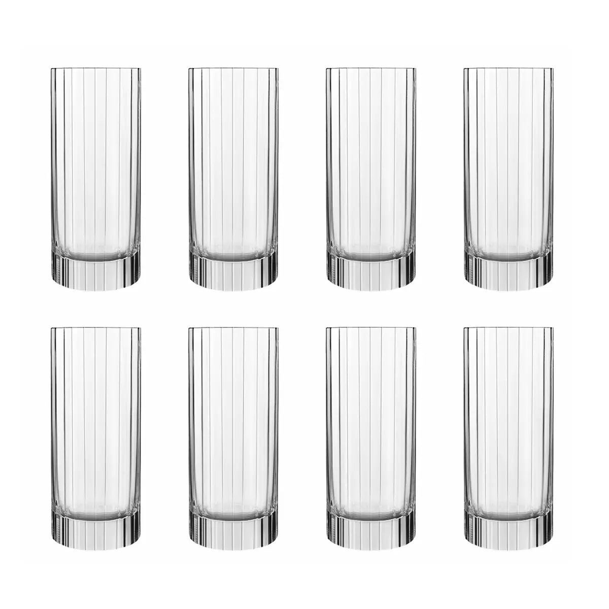 Eight Luigi Bormioli Bach hi-ball glasses arranged on a sleek marble bar top, showcasing their tall, fluted, and faceted crystal design.