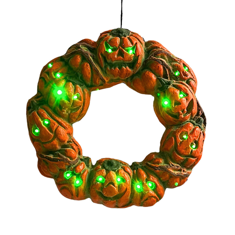 A 50cm multicolor luminous Halloween pumpkin wreath with twisted carvings and glowing eerie details hanging on a dark door.