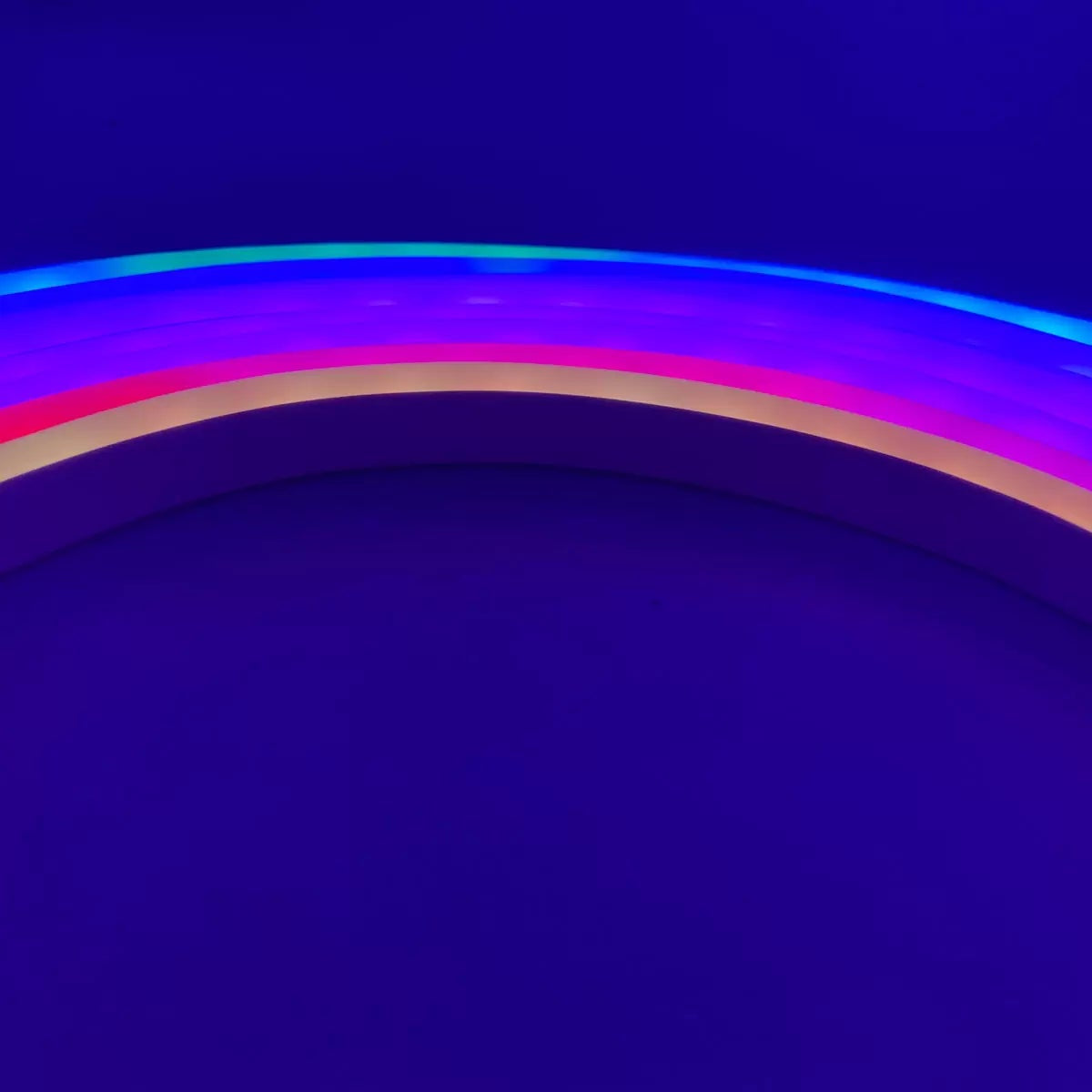 Flexible 5 meter Luminus Smart Wi-Fi Neon Strip Light mounted on a dark bedroom wall displaying colorful segmented RGBIC lighting effects.