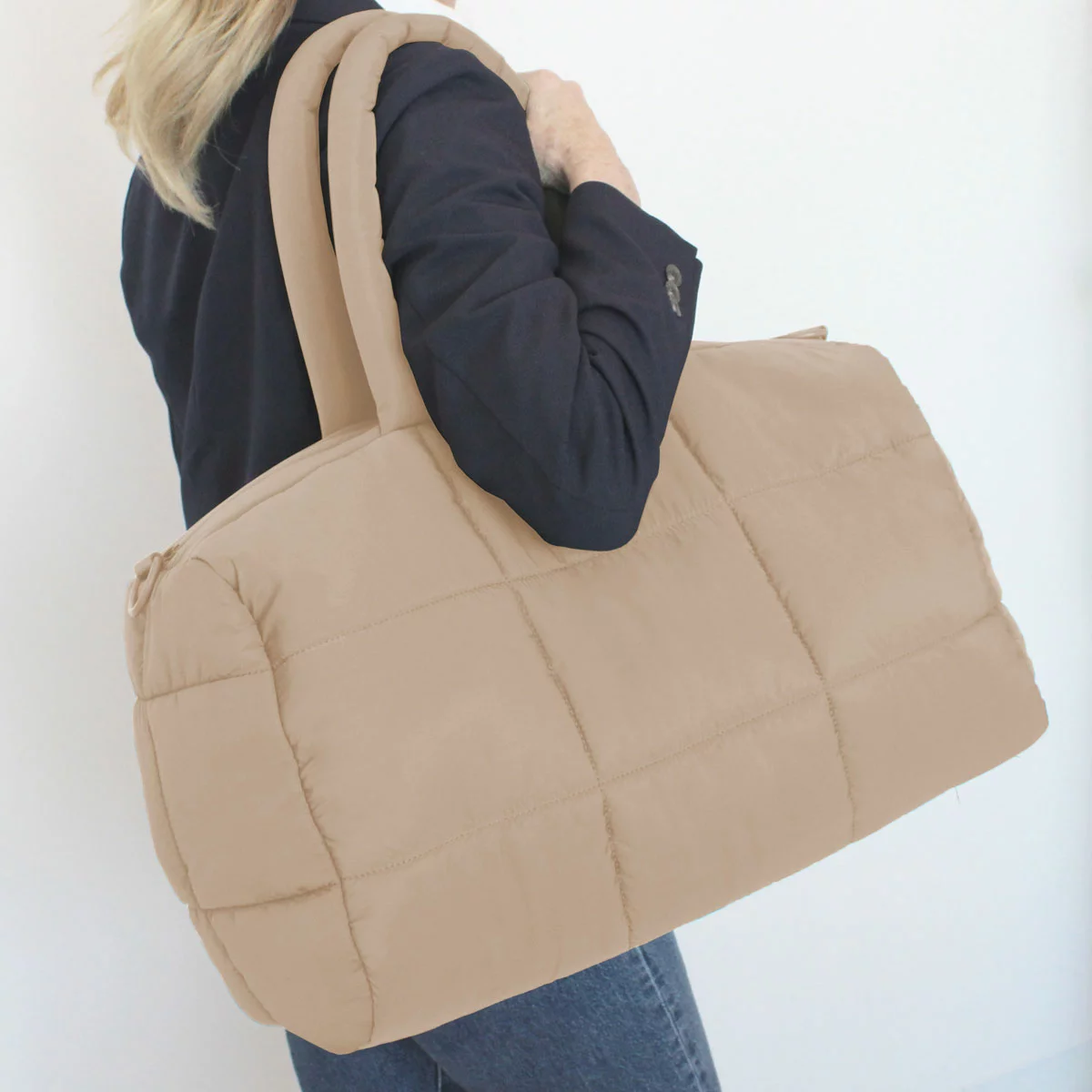 Front angle view of the soft MYTAGALONGS Cloud Duffle Weekender Bag showing its plush quilted polyester texture, top handles, and adjustable shoulder strap.
