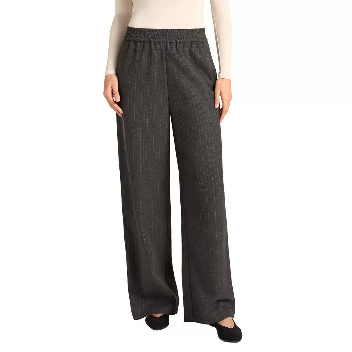 Front view of a woman wearing black Matty M high-rise pinstripe wide-leg pants paired with modern footwear in a bright studio setting.