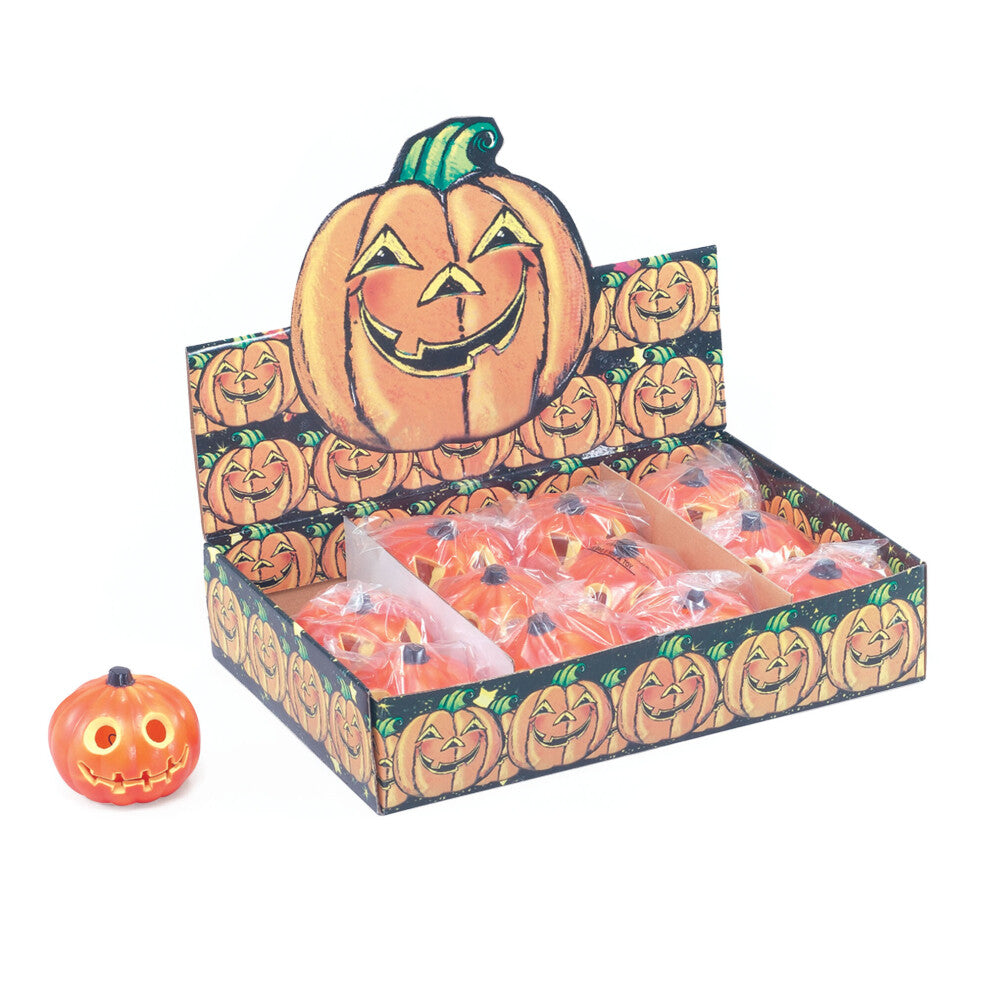 An official Forum HI106 light-up orange pumpkin prop glowing warmly on a dark wooden party table