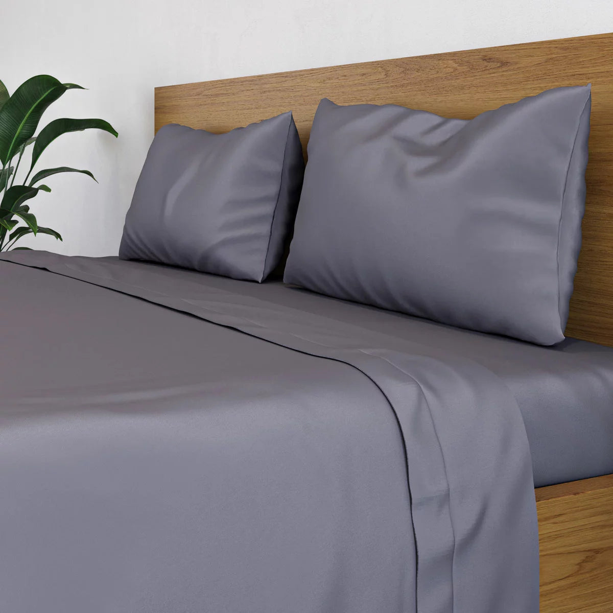 Dark grey Panda double bamboo flat sheet draped smoothly over a modern bed frame highlighting its silky texture and rich charcoal sheen.