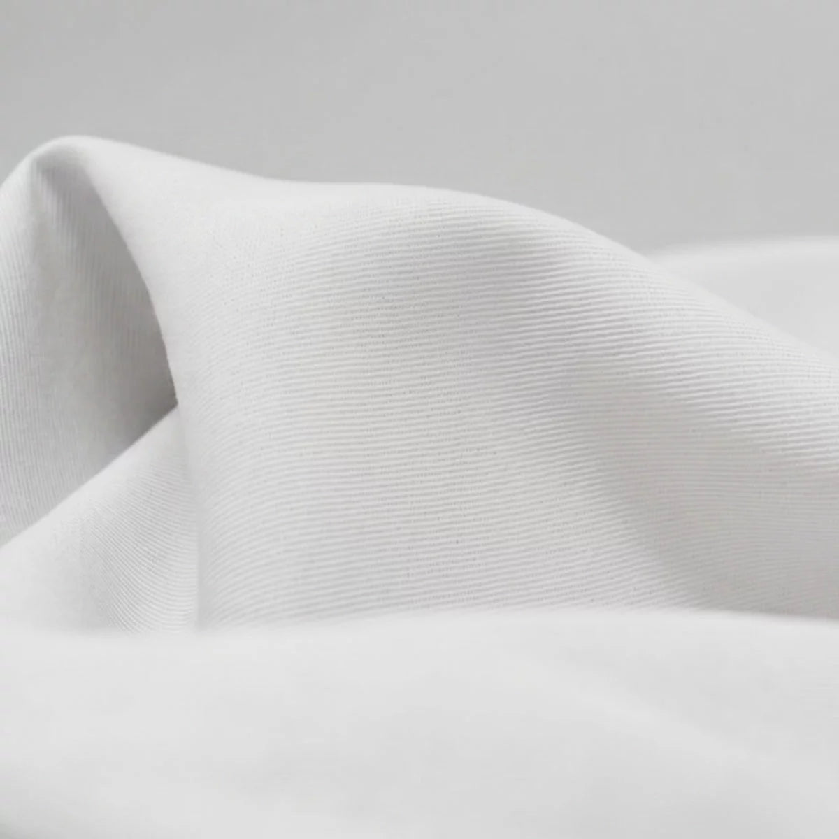 Crisp white Panda bamboo and French linen fitted sheet pulled taut over the corner of a deep mattress showcasing its textured matte finish.