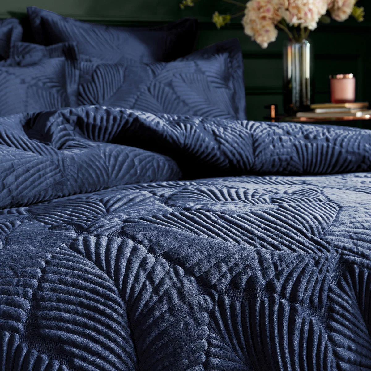 Deep navy blue Paoletti velvet duvet cover featuring gold palm embroidery with matching Oxford pillowcases styled on a modern bed.