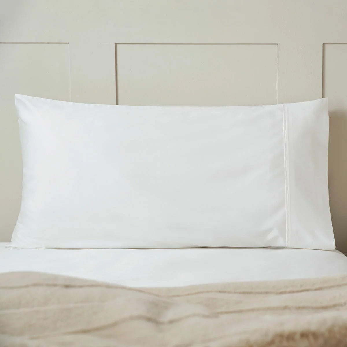 A pair of smooth, white Belledorm 450 thread count Pima cotton king-size pillowcases resting on a neatly dressed bed under soft morning light.