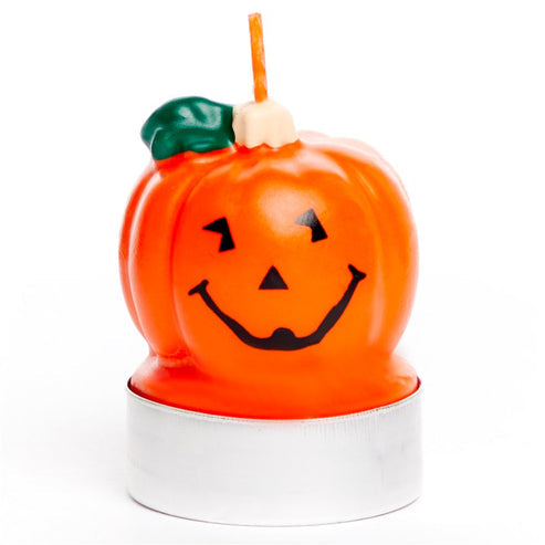 Three orange pumpkin shaped 5cm wax tea light candles arranged on a wooden rustic surface with a warm glowing flame.
