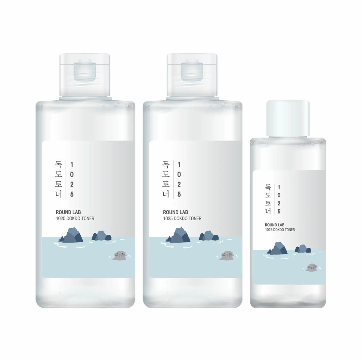The Round Lab 1025 Dokdo Toner set, featuring two large 200ml bottles and one 100ml bottle, presented on a minimalist platform with clear, refreshing lighting.