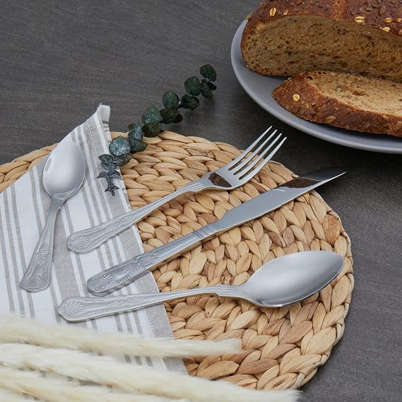 Russell Hobbs Verona 24 piece 18/10 stainless steel silver cutlery set including forks, knives, table spoons, and teaspoons displayed on a dining table.