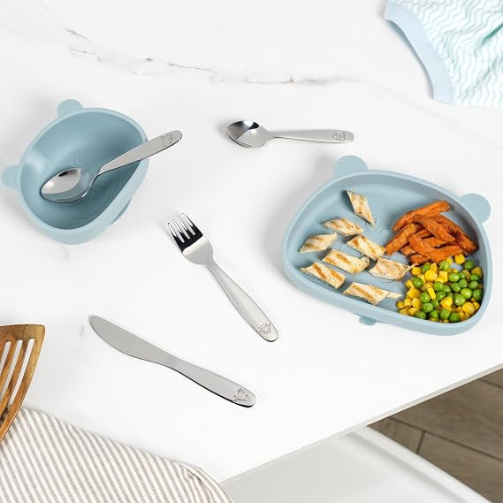 Salter 12-piece stainless steel kids cutlery set with farmyard animal engravings laid out on a clean light table setting.