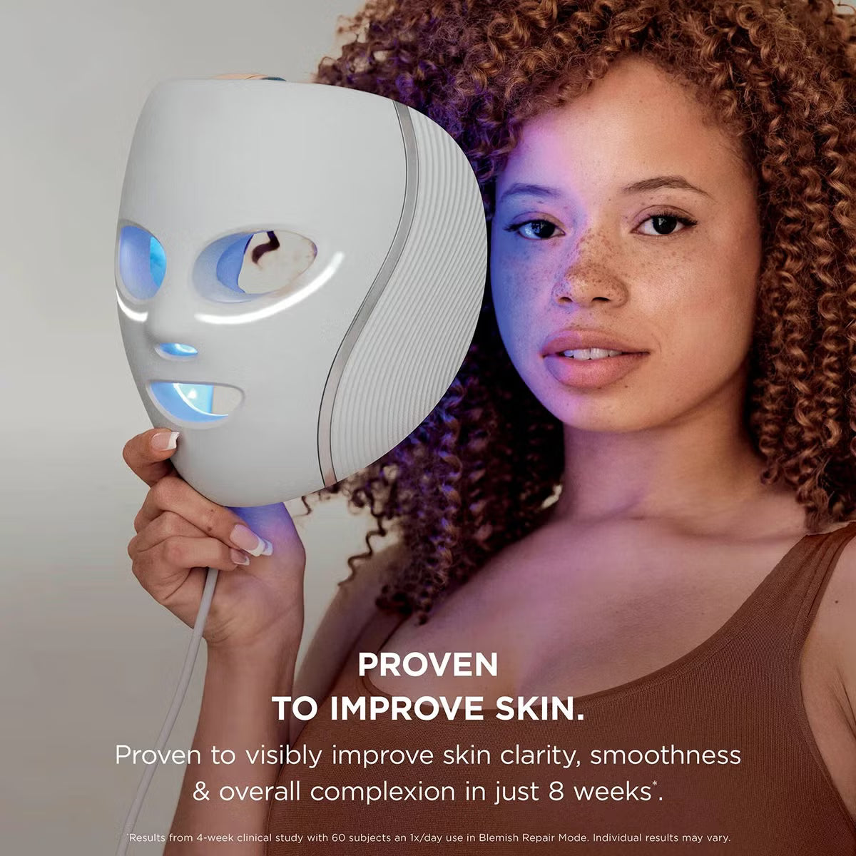 Shark CryoGlow LED therapy mask in Lilac Chill with silicone eye guards, attached handheld controller, and USB-C cable displayed on a white marble vanity.