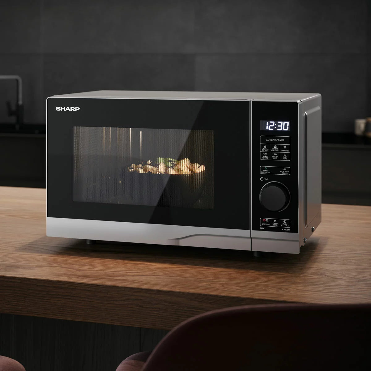Silver Sharp YC-PS204AU-S 20-litre solo digital microwave showing clean front panel, glass door, and digital display on a modern kitchen counter.