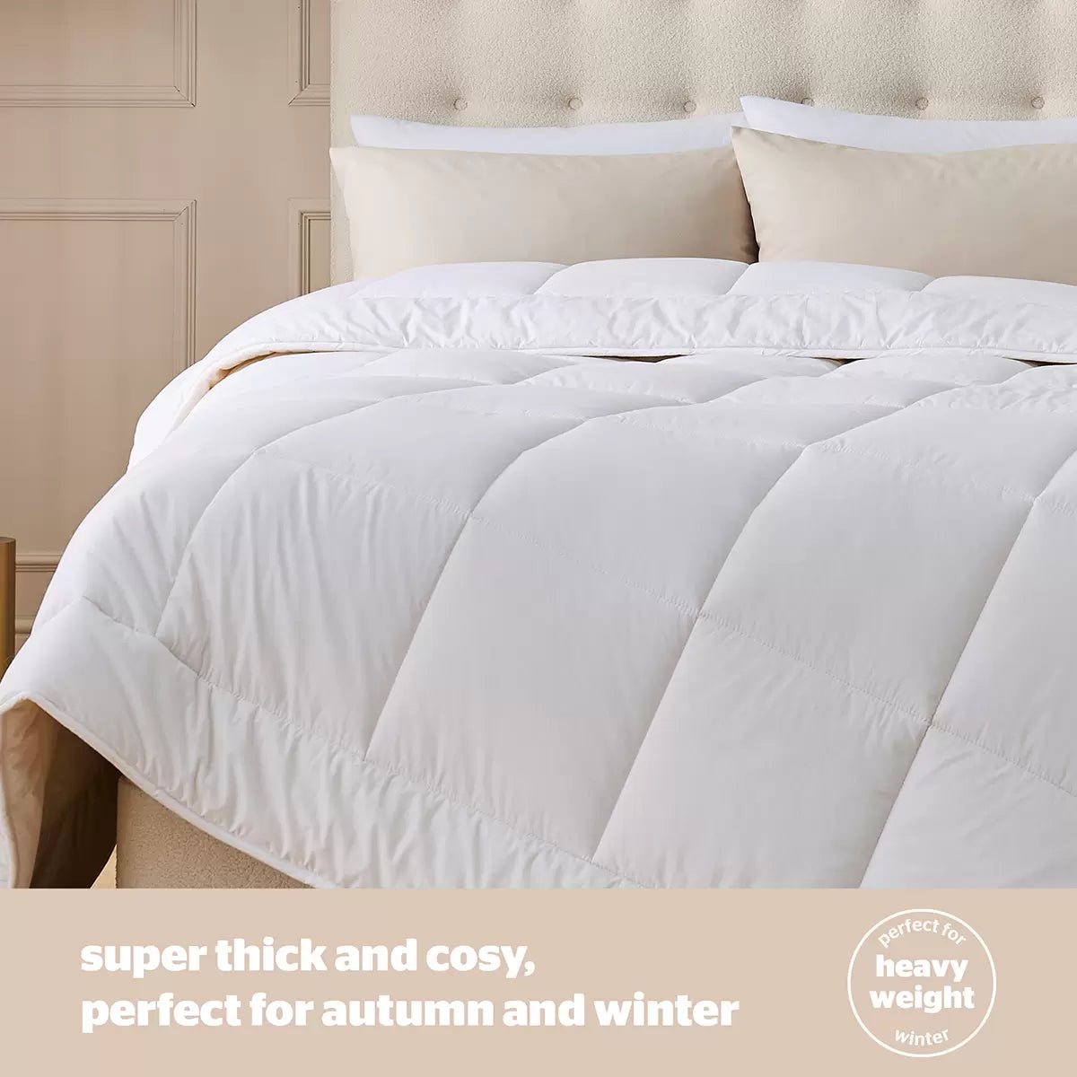 Angle view of a thick white Silentnight natural wool heavyweight duvet draped over a modern wooden bed frame in a cozy bedroom setting.
