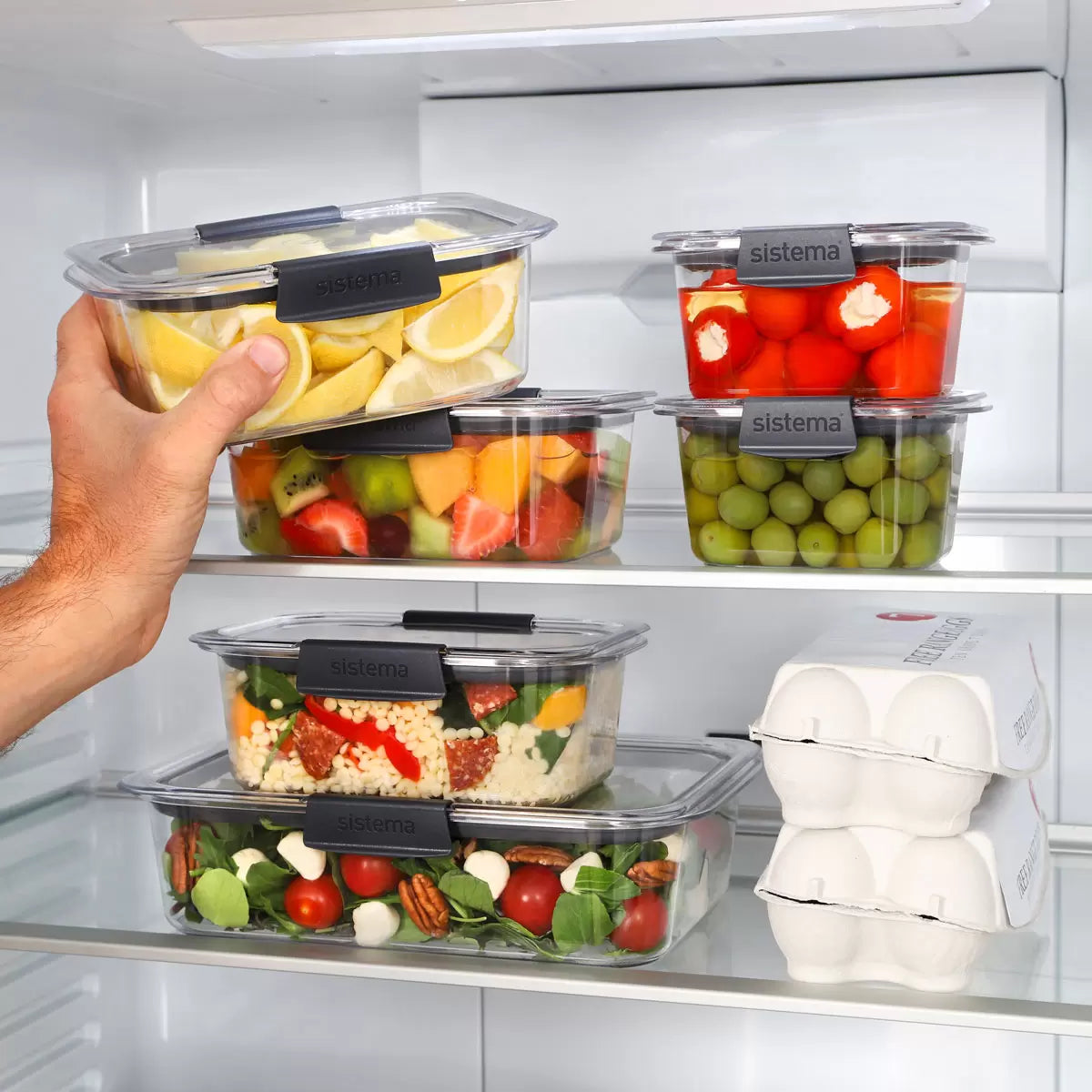 A 14-piece Sistema Brilliance food storage set organized neatly on a kitchen counter, showcasing clear containers and grey leak-proof lids.