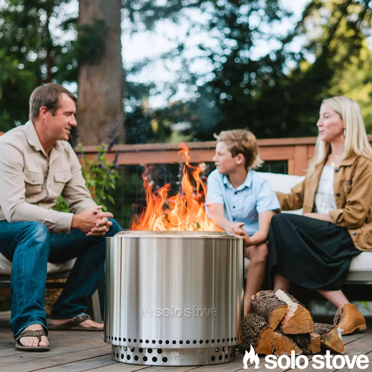 Solo Stove Bonfire 2.0 wood-burning stainless steel fire pit glowing with a vibrant, smokeless flame on a modern stone patio.