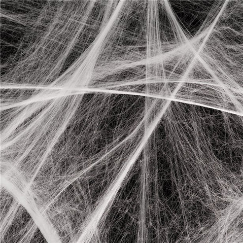 White stretchable synthetic spider web draped across a dark wooden doorframe with four small black plastic spiders embedded in the strands.