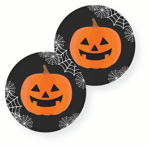 Flat lay of eight 23cm orange pumpkin paper plates with quirky black glasses printed on a wooden dining table alongside Halloween decor.