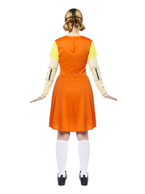 Adult wearing the orange pinafore dress and yellow collared shirt Squid Game doll costume standing in a full-length front view pose.