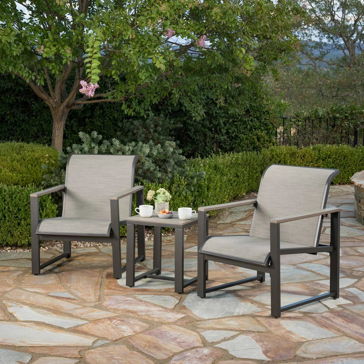 SunVilla Helio 3 Piece Bistro Set featuring a table and two chairs with a protective cover, arranged on a sunny patio.