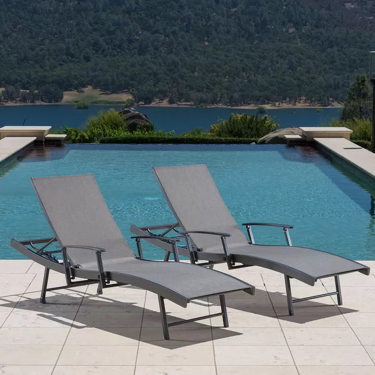 Set of two SunVilla Sling Wave Sun Loungers with folding arms positioned on a wooden deck by a garden pool.