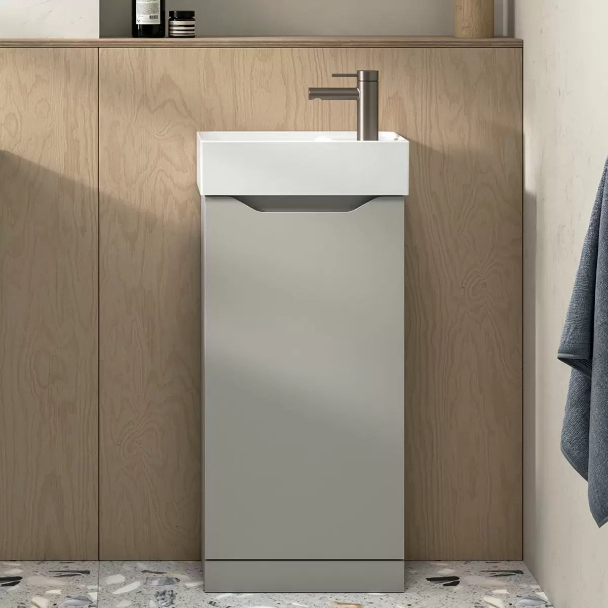 A compact floor-mounted white Tavistock Coda bathroom vanity unit featuring a reversible ceramic basin with a corner tap hole, installed in a modern minimalist cloakroom setting.