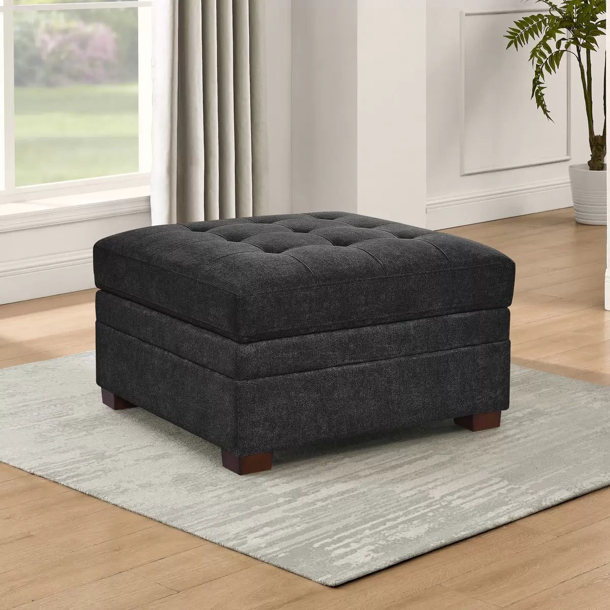 Thomasville Tisdale dark grey fabric storage ottoman with tufted top in a modern living room setting.