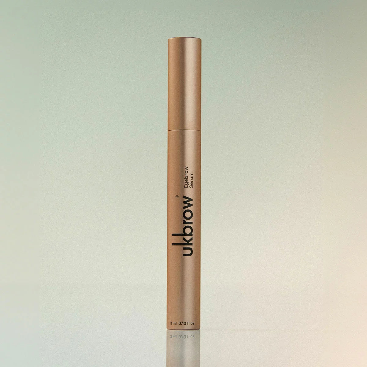 Two sleek tubes of UK Brow Eyebrow Serum with a precision applicator wand resting gently on a polished marble vanity top.