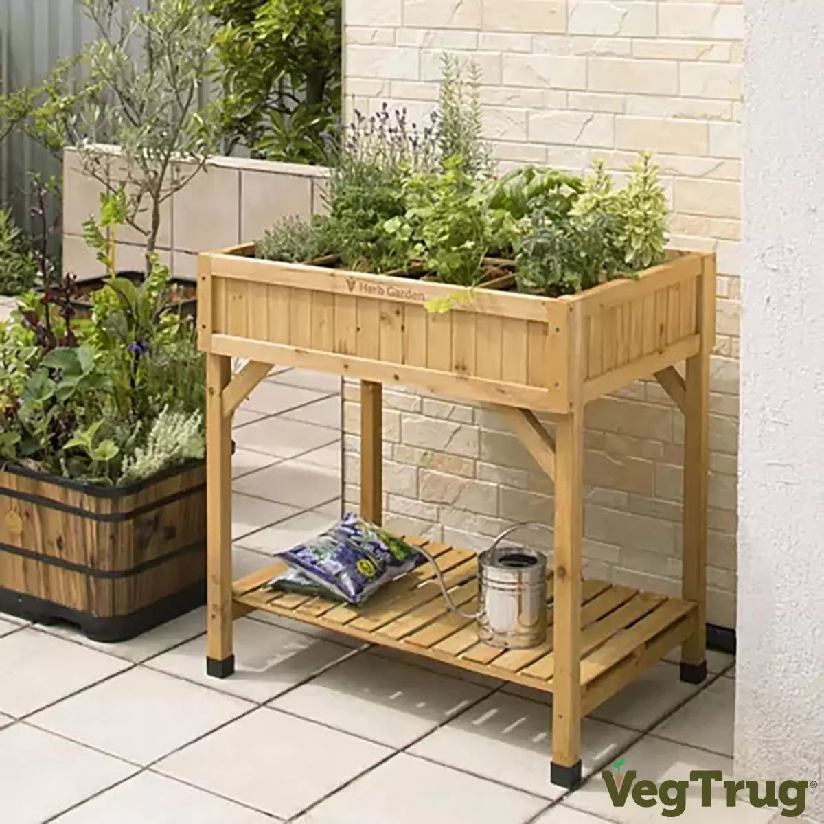 A cedar wood VegTrug 8-pocket herb garden standing on a patio, with various herbs like rosemary, mint, and parsley growing in separate compartments.