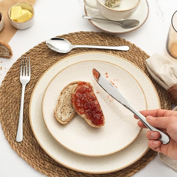 Silver Salter Bakewell 24 piece mirror polished stainless steel cutlery set arranged on a formal dinner table setting.